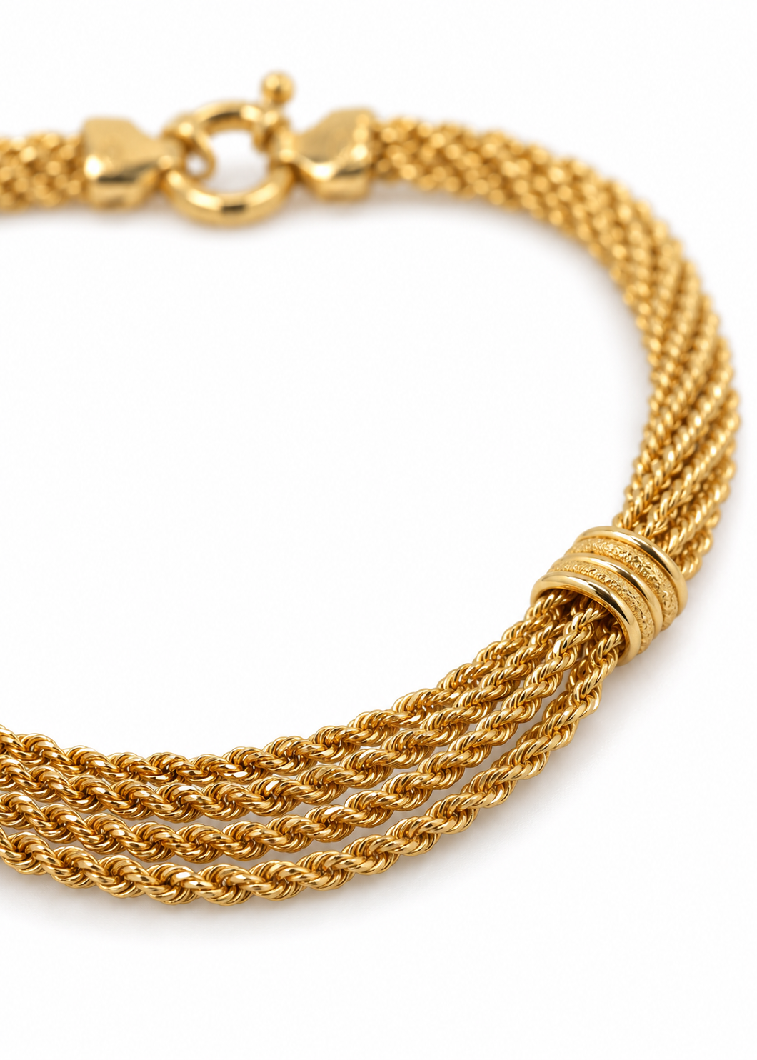 Close-up of layered Italian 18K yellow gold rope chains and a ribbed decorative accent.