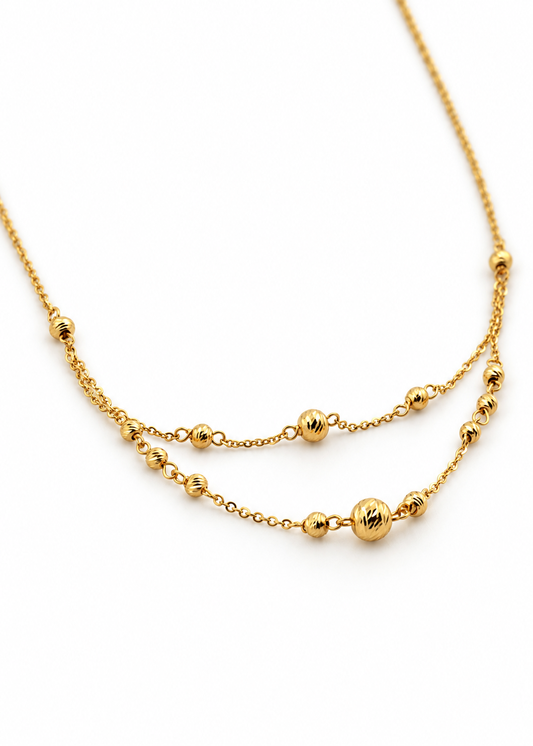 Close-up of the engraved gold beads and fine cable links on the Italian 18K gold Station Necklace.